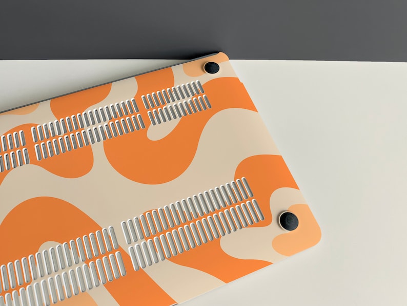 May include: A laptop case with a white and orange abstract pattern. The case has a vent on the back and two black rubber feet.