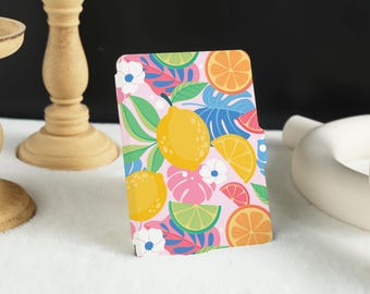 May include: A pink and white patterned case with a tropical theme. The case features lemons, oranges, and palm leaves.