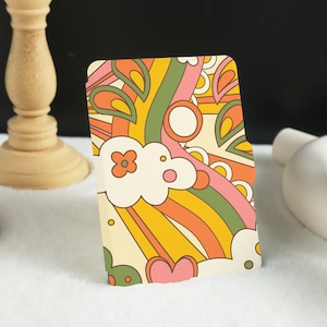 May include: A colorful card with a retro design featuring swirls, hearts, and flowers in shades of pink, orange, yellow, and green.