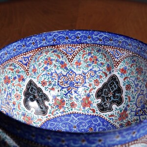 May include: A blue and white ceramic bowl with intricate floral and geometric patterns. The bowl has a raised rim and a scalloped edge.
