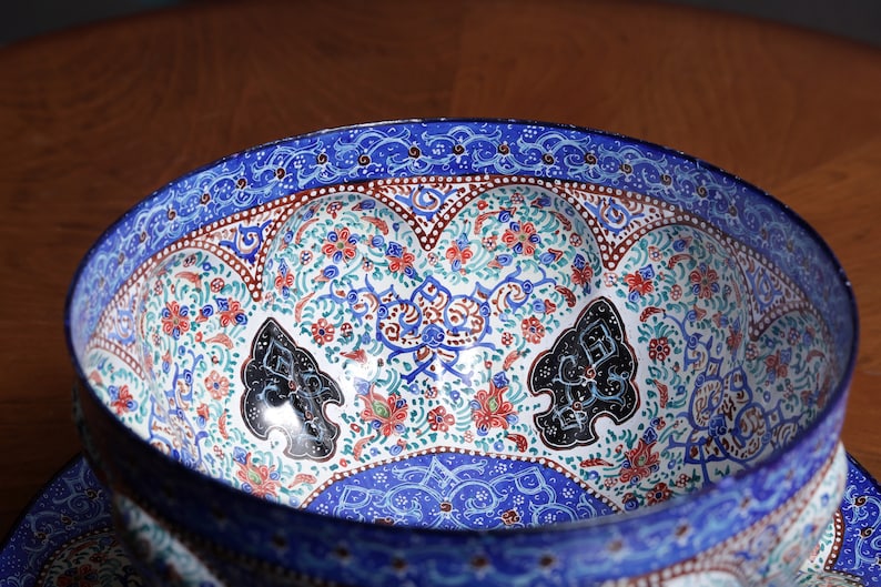 May include: A blue and white ceramic bowl with intricate floral and geometric patterns. The bowl has a raised rim and a scalloped edge.