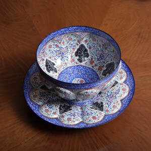 May include: A blue and white ceramic bowl with intricate floral and geometric designs. The bowl is sitting on a matching plate.