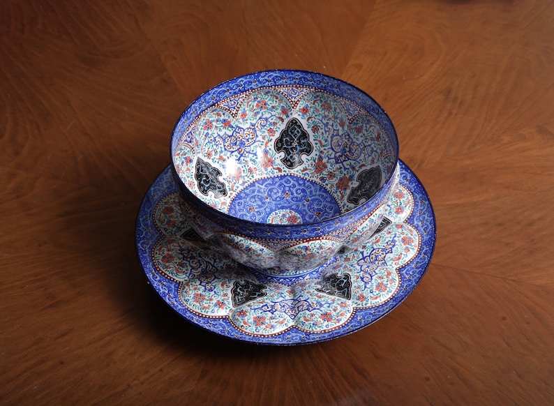 May include: A blue and white ceramic bowl with intricate floral and geometric designs. The bowl is sitting on a matching plate.