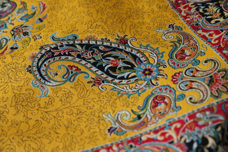 May include: A yellow fabric with a paisley pattern in shades of blue, red, green, and black. The fabric has a traditional Persian design.