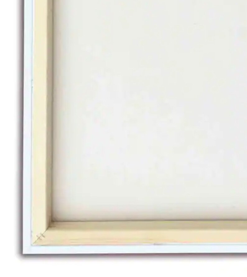 Pode incluir: Um close-up da borda inferior de uma pintura em tela branca com uma moldura de madeira. A moldura &eacute; de cor marrom claro e tem uma borda branca.