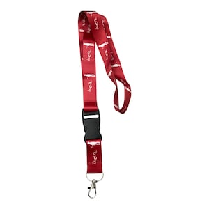 May include: A red lanyard with a black clip and a silver hook. The lanyard has a white print of the word "LCA" repeated multiple times.