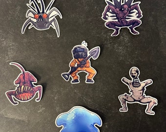 May include: A set of six colorful stickers featuring various cartoon characters. The stickers include a blue blob, a creature with a shovel, a creature with wings, a creature with a gas mask, a creature with a mouth, and a creature with a long neck.