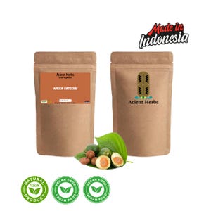 Könnte beinhalten: Zwei braune Papiertüten mit Kräuterergänzungsmitteln mit dem Text "Acient Herbs" und "ARECA CATECHU". Das Bild enthält frische grüne Blätter und Früchte sowie drei "Vegan Food"- und ein "Natural Product"-Etikett. Der Text "Made in Indonesia" ist ebenfalls sichtbar.