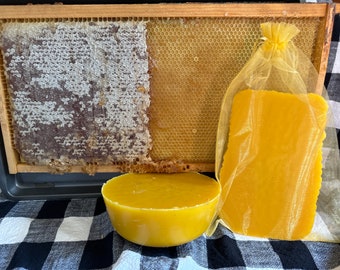 May include: Three blocks of beeswax, one in a yellow mesh bag, one in a round shape, and one in a honeycomb frame.