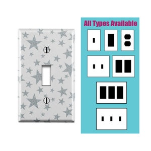 May include: A white light switch cover with a silver glitter star pattern. The text "All Types Available" is displayed above a variety of switch and outlet plate styles.