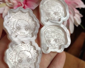 Könnte beinhalten: Drei weiße Harzformen mit Zeichentrickfiguren-Designs. Die Formen sind kreisförmig und haben einen erhöhten Rand. Die Figuren sind in Schwarzweiß gezeichnet und haben einen Manga-Stil.