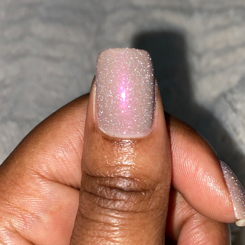 Puede incluir: Primer plano de un dedo con un esmalte de u&ntilde;as rosa claro con un acabado brillante. La u&ntilde;a es corta y de forma cuadrada.