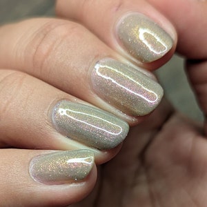 Puede incluir: Primer plano de cuatro u&ntilde;as pintadas con un esmalte de u&ntilde;as verde claro con un brillo sutil.