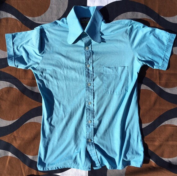 Get down and get FUNKY in this 1970s body-hugging short-sleeve stretch shirt with extra-funky collar and contrast red buttons Medium