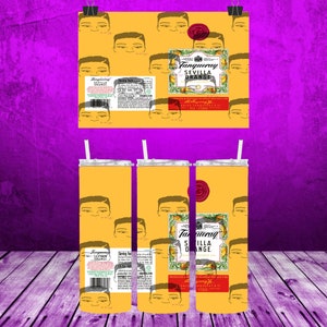 May include: Three yellow stainless steel tumblers with a repeating pattern of a man's face and the text "Tanqueray Sevilla Orange" on the front. The tumblers have a silver lid and a straw.