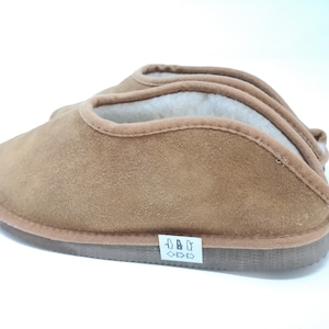 Peut inclure: Une paire de pantoufles en daim marron avec une doublure douce et moelleuse. Les pantoufles ont un design simple et sont parfaites pour garder vos pieds au chaud et à l'aise.