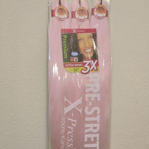 May include: Baby pink pre-stretched braiding hair by Outre X-Pression. The package includes three bundles of 52-inch ultra braid hair. The packaging features the brand name, product details, and a picture of a woman.