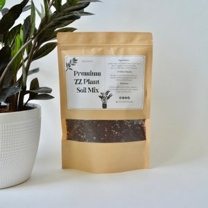 May include: A brown paper bag with a clear window showing a dark brown soil mix. The bag has a white label that says "ORGANIC Premium ZZ Plant Soil Mix" and lists the ingredients and directions for use. The label also includes the social media handle @CYCLEOFPLANT.