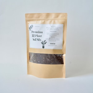 May include: A brown paper bag with a clear window showing a dark brown soil mix. The bag has a white label that says "Organic Premium TZ Plant Soil Mix" and lists the ingredients and directions for use. The label also includes the social media handle @CYCLEOFPLANT.