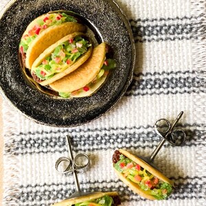 Peut inclure: Une paire de boucles d'oreilles en forme de taco argent&eacute;es avec un design r&eacute;aliste. Les boucles d'oreilles pr&eacute;sentent un petit taco d&eacute;taill&eacute; avec une tortilla jaune, de la laitue verte, une tomate rouge et une garniture brune. Les boucles d'oreilles sont parfaites pour ajouter une touche amusante et d&eacute;cal&eacute;e &agrave; n'importe quelle tenue.