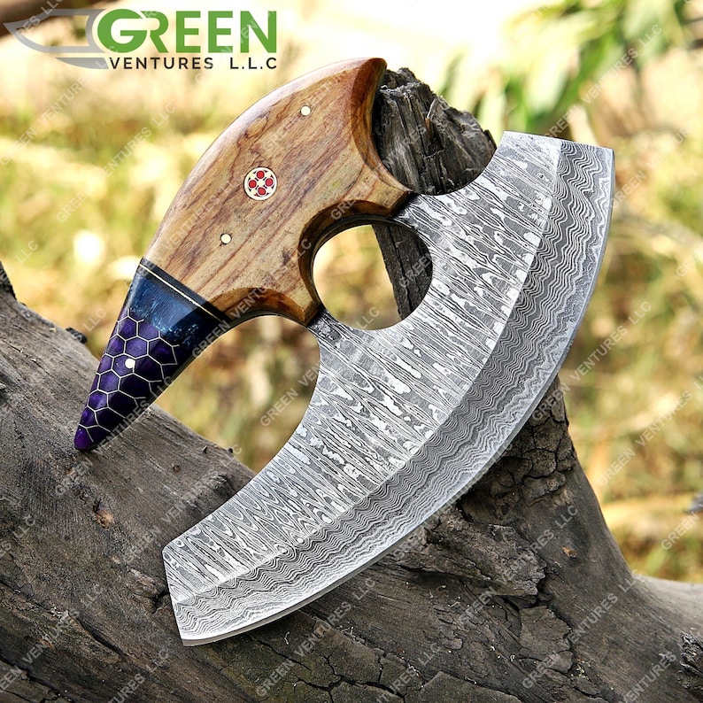 May include: A large, curved, stainless steel cleaver with a wooden handle. The handle is decorated with a blue and purple pattern. The blade has a wavy, damascus pattern.