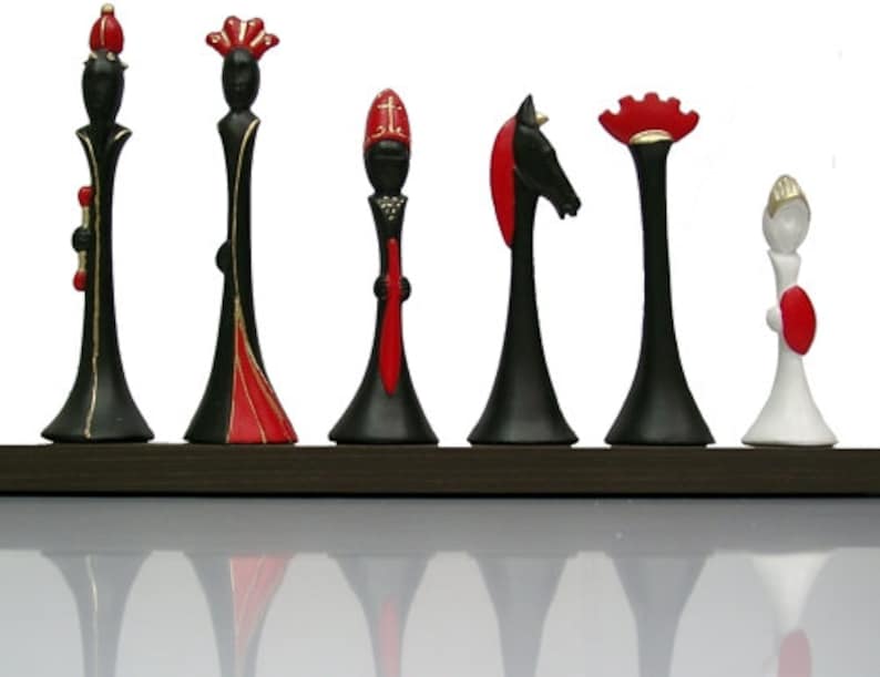 Pu&ograve; includere: Un set di sette pezzi degli scacchi, ognuno con un design unico. I pezzi sono in ceramica e sono dipinti in nero, bianco e rosso. I pezzi sono disposti in fila su una superficie marrone scuro.