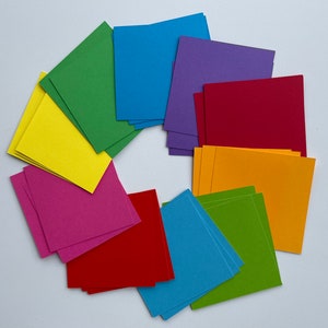 Peut inclure: Un ensemble de 10 carrés de papier colorés dans différentes nuances de bleu, vert, jaune, rouge, violet et orange. Les carrés sont disposés en cercle, les bords se chevauchant.