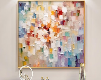 Puede incluir: Pintura abstracta con un diseño colorido, texturizado y en capas. La pintura presenta una variedad de colores, incluyendo blanco, amarillo, naranja, rojo, morado y azul. La pintura está enmarcada en un marco dorado.