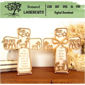 May include: Two wooden cross-shaped laser-cut decorations. Each cross features a nativity scene with figures and text. One reads "For unto you is born this day..." and the other "Oh Come Let us adore Him." The top banner reads "Treasured Lasercuts".