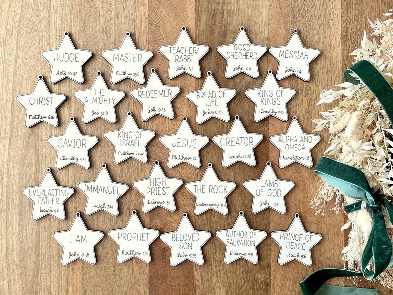 May include: Twenty white wooden star ornaments with black text. Each star features a different name or title for Jesus, along with a corresponding Bible verse.