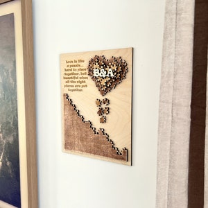 May include: A wooden heart-shaped puzzle with the letters "B&A" in the center. The puzzle is surrounded by a quote about love being like a puzzle, hard to place together, but beautiful when all the right pieces are put together.