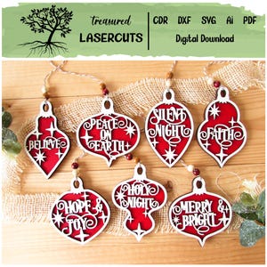 Könnte beinhalten: Weihnachtsschmuck aus Holz mit roten und weißen Designs. Jeder Schmuckanhänger trägt eine festliche Botschaft wie "Believe", "Peace on Earth" und "Merry & Bright". Die Ornamente sind an einer Schnur aufgehängt.