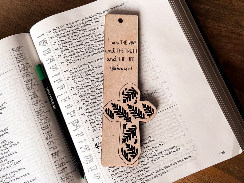 May include: A wooden bookmark with a cross design and a floral pattern. The bookmark has the text "I am the way and the truth and the life (John 14:6)" printed on it.