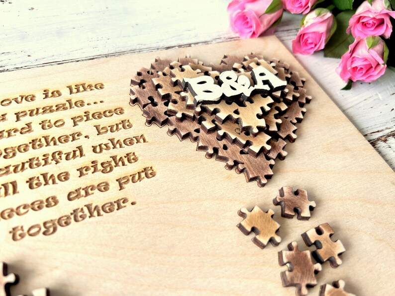 May include: A wooden heart-shaped puzzle with the letters "B&A" on top. The puzzle is on a light wood background with the text "Love is like a puzzle... hard to piece together, but beautiful when all the right pieces are put together."