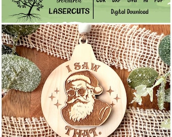 Puede incluir: Un adorno navideño de madera con un diseño de Santa Claus con gafas de sol y el texto "I SAW THAT." cortado con láser.