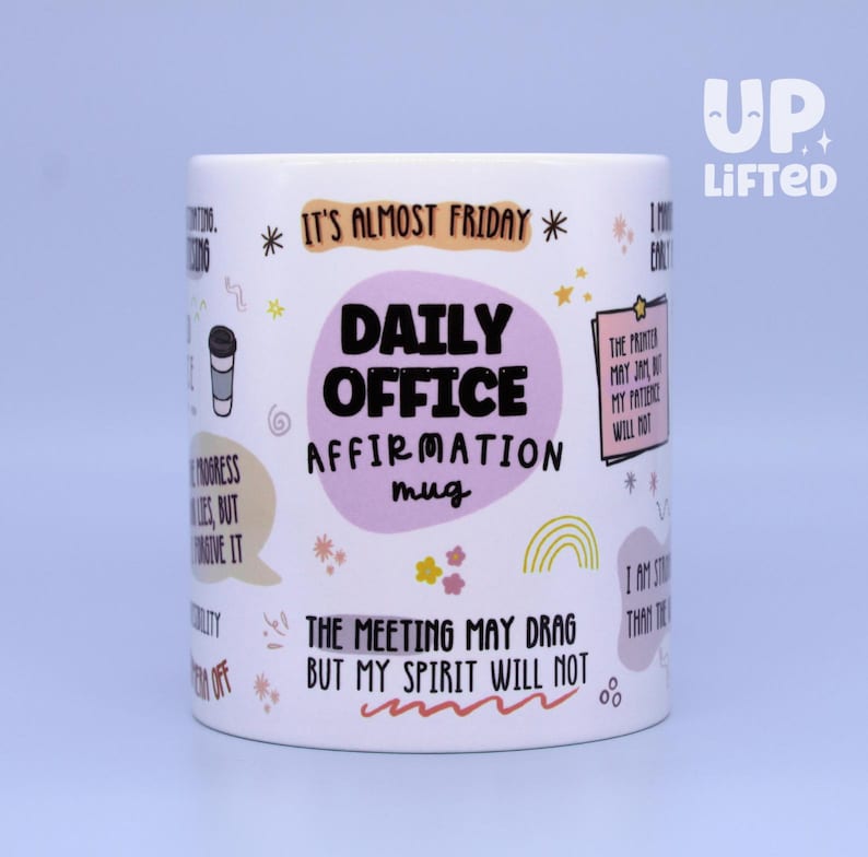 Pu&ograve; includere: Tazza in ceramica bianca con la scritta "DAILY OFFICE AFFIRMATION mug" in nero e un ovale viola chiaro. La tazza presenta varie affermazioni e frasi, tra cui "It's almost Friday" e "The meeting may drag but my spirit will not."