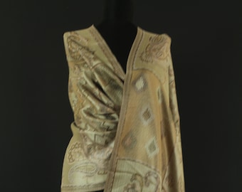 May include: A beige shawl with a paisley pattern and fringe. The shawl is draped over a mannequin.