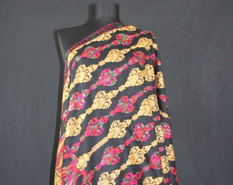 May include: A black shawl with gold and pink floral embroidery. The shawl has a paisley design and a fringed edge.