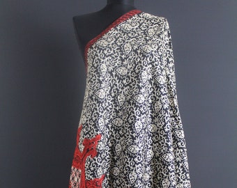 May include: A black shawl with a white and red floral pattern. The shawl is draped over a mannequin.
