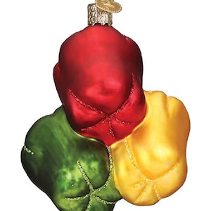Puede incluir: Adorno navideño decorativo con forma de tres pimientos en rojo, verde y amarillo. El adorno tiene un acabado brillante con detalles de purpurina y una tapa de metal dorado con un dije en forma de corazón.
