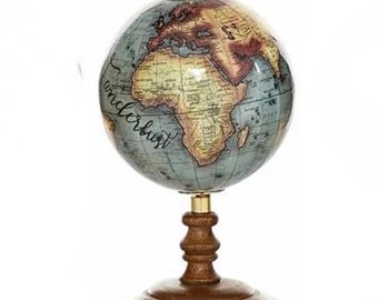 Könnte beinhalten: Ein Globus im Vintage-Stil mit einer blauen und braunen Karte, einem Holzsockel und dem Wort "Wanderlust" auf der Seite.