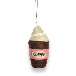 May include: A felt coffee cup ornament with a pink band and the word "COFFEE" embroidered on it. The cup is decorated with white sequins.