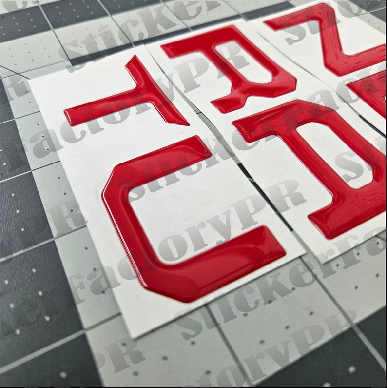 May include: Three red, 3D plastic letters, "C", "T", and "Z", on a white background. The letters are raised and have a glossy finish.