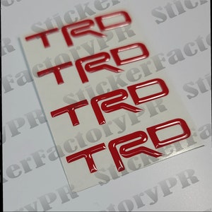 May include: Four red 3D "TRD" stickers on a white background. The stickers are glossy and have a raised design.