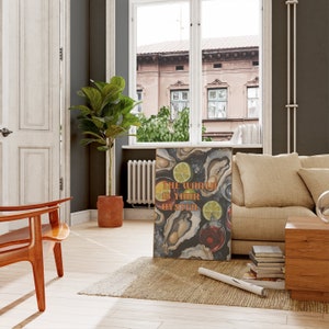 May include: A framed art print with the text "The World Is Your Oyster" in orange and white. The print features illustrations of oysters, lime slices, and drinks on a dark background. The artwork is displayed in a living room setting.