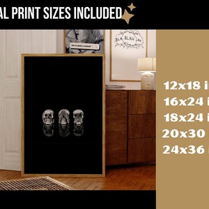 May include: A framed black and white print showing three skulls, each with a different pose: one with eyes open, one with hands covering the eyes, and one with hands covering the mouth. Available in sizes such as 30x46 cm and 61x91 cm.