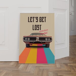K&ouml;nnte beinhalten: Ein Vintage-Poster mit einem roten Muscle-Car, das eine Regenbogenstra&szlig;e entlangf&auml;hrt. Das Poster tr&auml;gt den Text "Let's Get Lost somewhere beautiful".