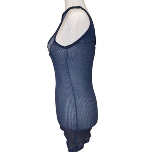 May include: A navy blue sleeveless top with a delicate lace trim around the neckline and hem. The top is made of a lightweight, breathable fabric and has a fitted silhouette.