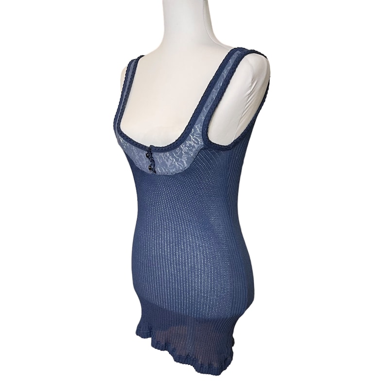 May include: A navy blue tank top with a lace trim and a single button at the neckline.