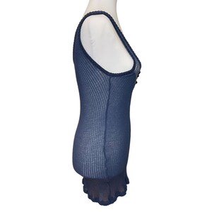 May include: A navy blue tank top with a lace trim and a ruffled hem. The tank top is made of a lightweight, breathable fabric.